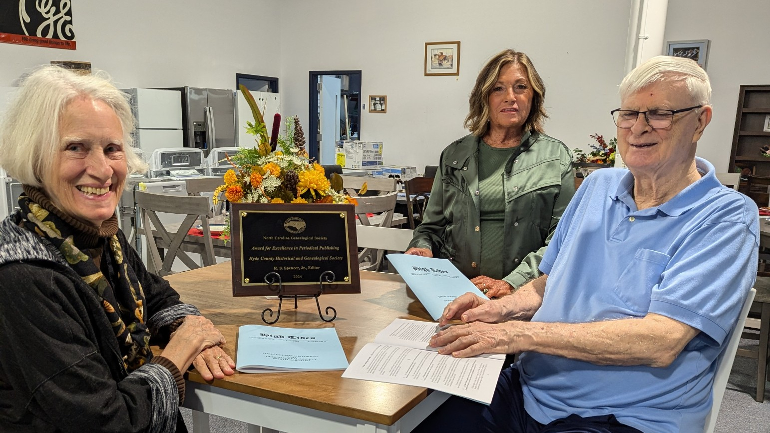 People at a table that has an award on it.