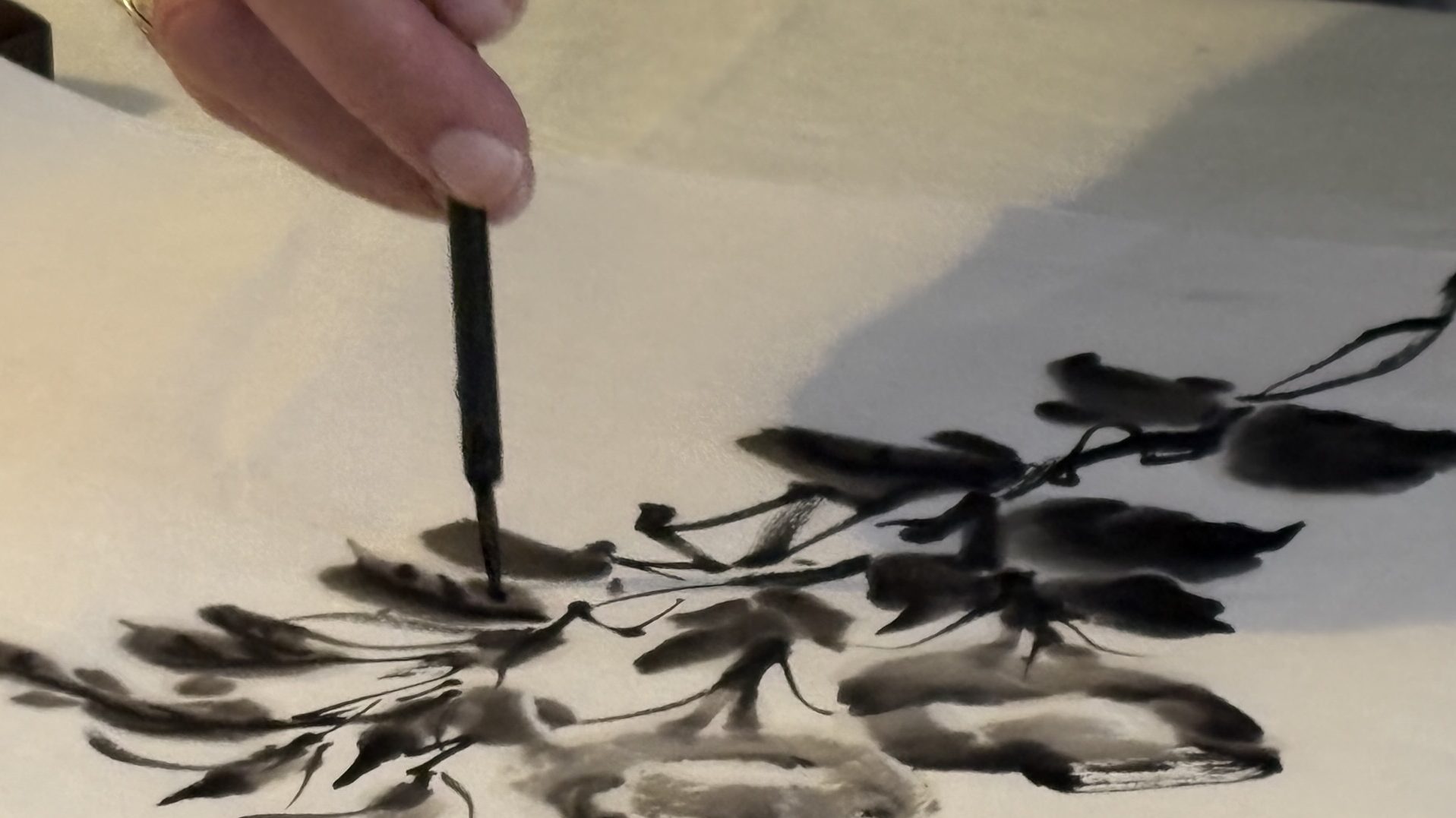 Mike Lane paints details into leaves during a demonstration.